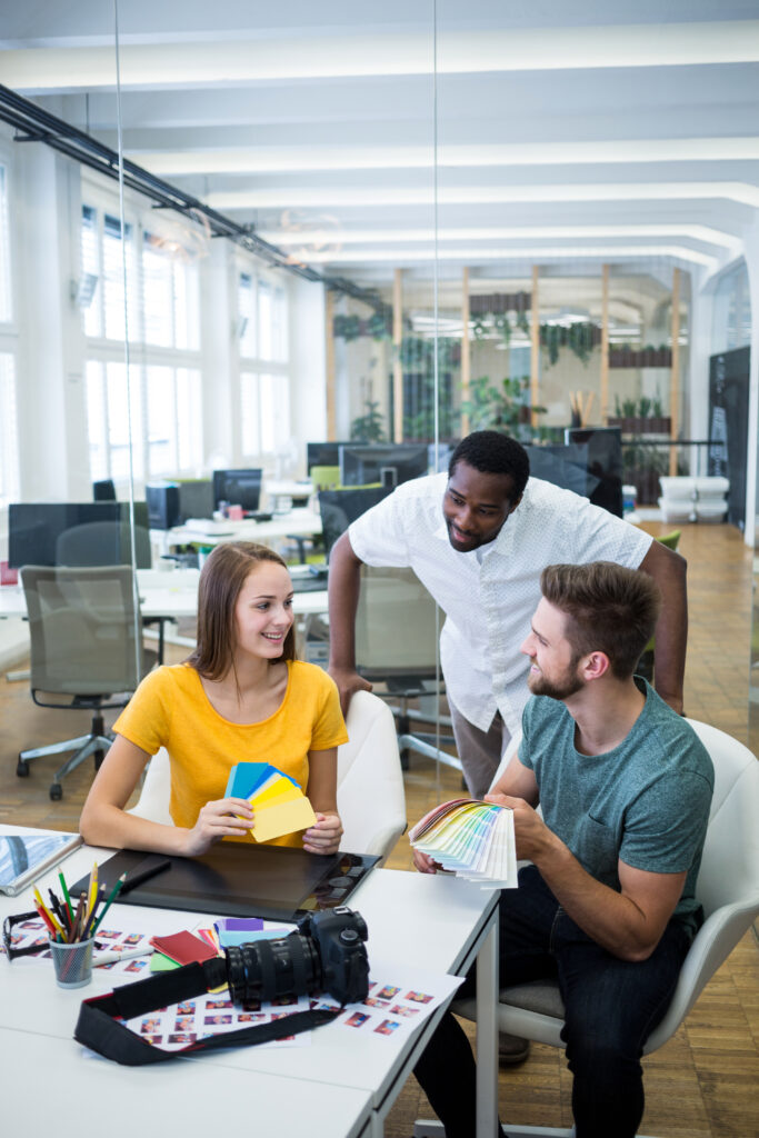 Male and female graphic designers interacting with each other in office